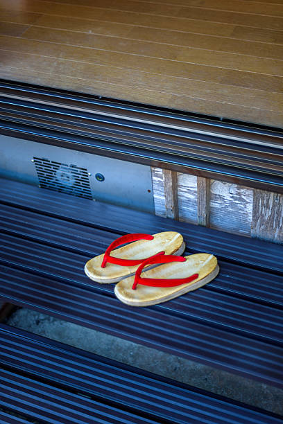 High angle view of traditional Japanese geta sandals resting on tatami mat for guest use at Tokyo ryokan.