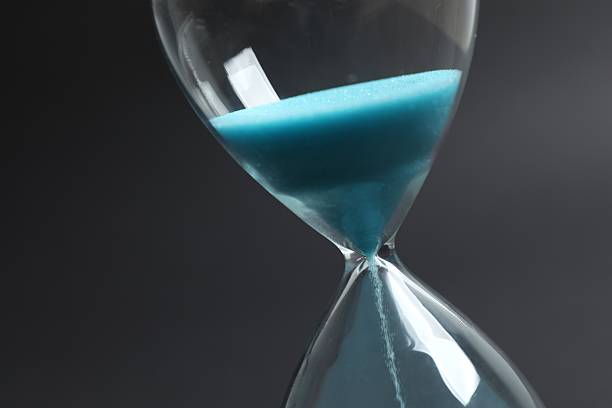 istock Close-up view of hourglass on black background 2248927565