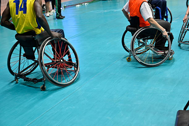 Dynamic scene of wheelchair basketball players competing on an indoor court, showcasing adaptive sports, inclusion, teamwork and the determination of disabled athletes in a high-energy sporting environment.