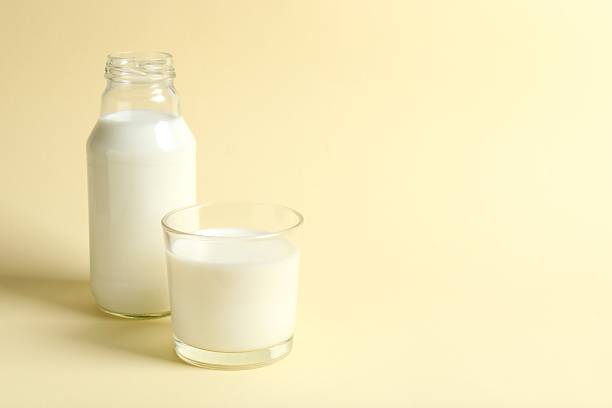 istock Milk in a glass on beige background 2248928843