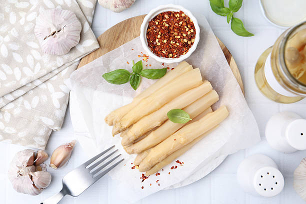 istock Pickled asparagus spears served on white tiled table, flat lay 2248928948