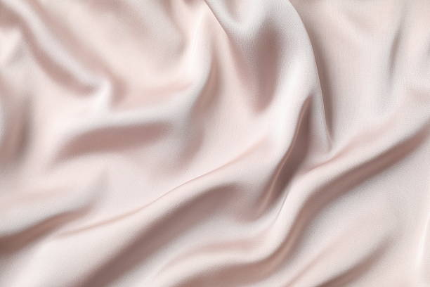 istock Beige silk satin. Shiny smooth fabric. Soft folds. Luxury background with space for design. Flat table, top view 2248930689