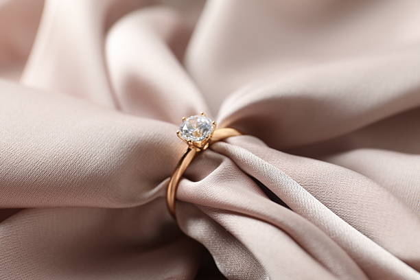 istock Close-up of engagement ring on silk fabric 2248930784