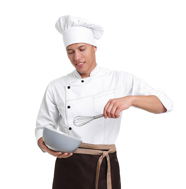Portrait of professional chef in uniform with bowl and whisk on white background