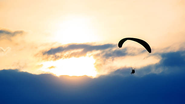 istock Paraglider soaring above clouds during sunset creates breathtaking view in evening sky 2248931138