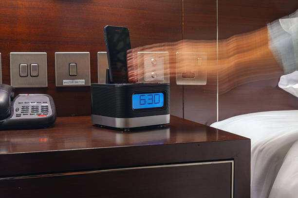 istock Early Morning Wake-Up Motion with Digital Alarm Clock, Smartphone Dock, and Blurred Hand Gesture Beside a Hotel Bedside Table in a Modern Interior 2248931488