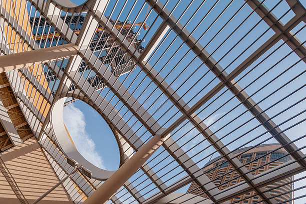 A modern architectural roof structure featuring geometric metal beams, circular cutouts, and clean contemporary lines with a clear blue sky visible above, captured in Dubai, United Arab Emirates, offering strong visual symmetry and ample copy space for design, branding, and creative concepts