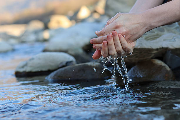 istock Hands cupping splashing water in a rocky stream, capturing the flow. 2248931709