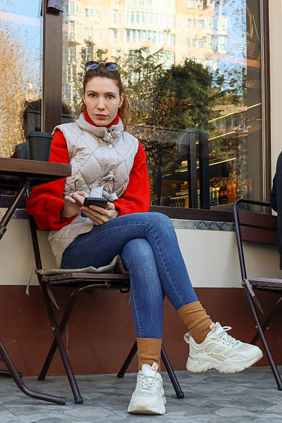istock Young woman using smartphone at outdoor cafe with coffee 2248932062