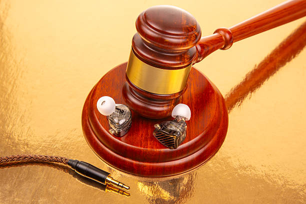 istock Gavel and earphones arranged on a reflective surface with a golden background 2248932068