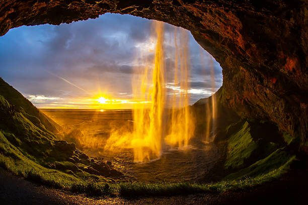 istock Majestic waterfall cascading from a cave with a sunset glow in Iceland 2248933456