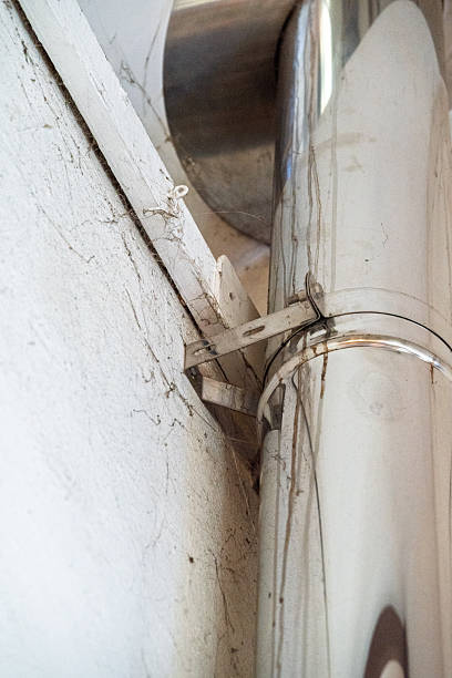 istock Close-up of a dusty chimney pipe and wall bracket. 2248935597