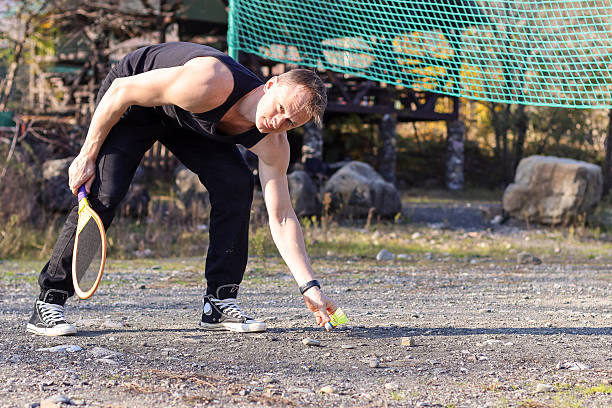Young athlete exercising with an elastic band in an urban park, surrounded by vibrant autumn foliage, embracing a healthy lifestyle