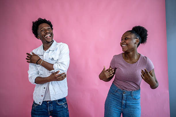 Friends dancing having fun on a pink background