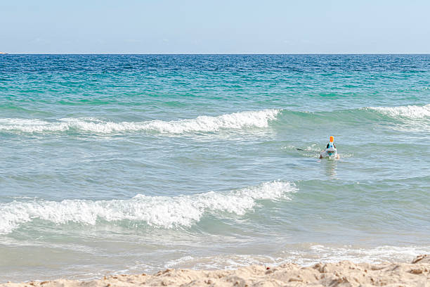 Turquoise waves near a sandy shore on a clear, bright, sunny day.