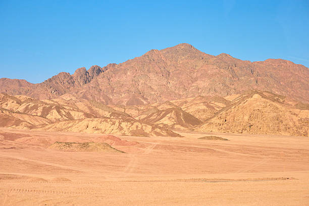 Vast desert terrain features striking mountains and sandy plains, showcasing natural beauty and tranquility