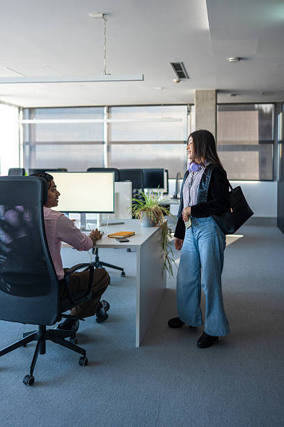istock Young Hispanic Woman Engaging Colleague in Modern Office Environment 2248940740