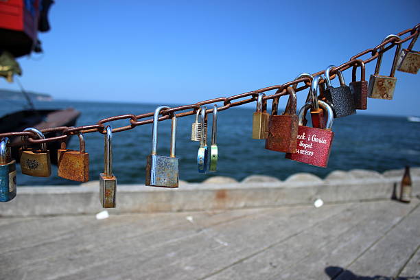 Rusty metal chain with colorful love locks hanging above the sea at the Sopot pier, Poland. Photo taken on June 5, 2019. Editorial use only.