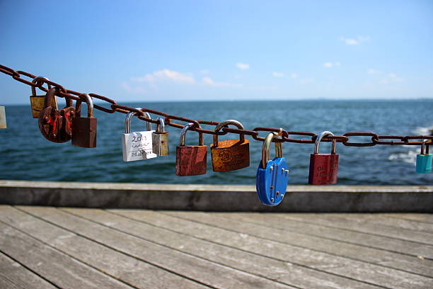 Rusty metal chain with colorful love locks hanging above the sea at the Sopot pier, Poland. Photo taken on June 5, 2019. Editorial use only.