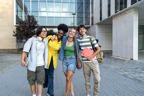 istock Diverse students smiling holding books on college campus 2248948021
