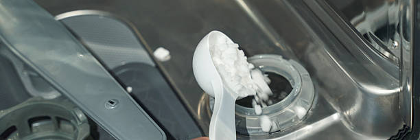istock Adding dishwasher salt with white measuring spoon in stainless steel dishwasher 2248948578