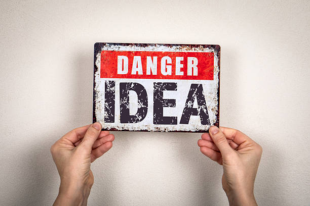 istock Hands Holding a Distressed Metal Sign Reading Danger Idea on a Neutral Wall 2248951540