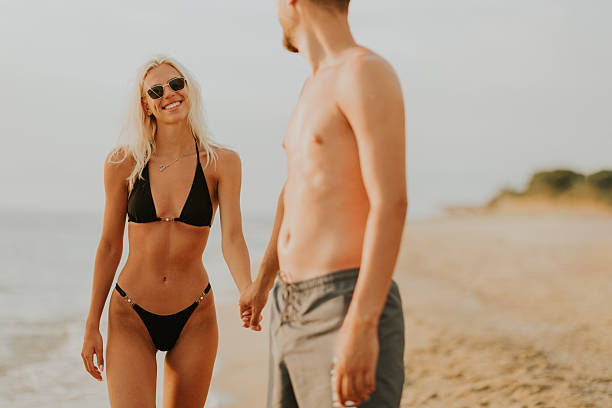 istock Couple enjoying a sunny beach day while holding hands and smiling 2248952857