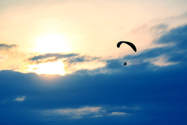 istock Skydiver soaring through clouds during sunset with vibrant colors above 2248954580