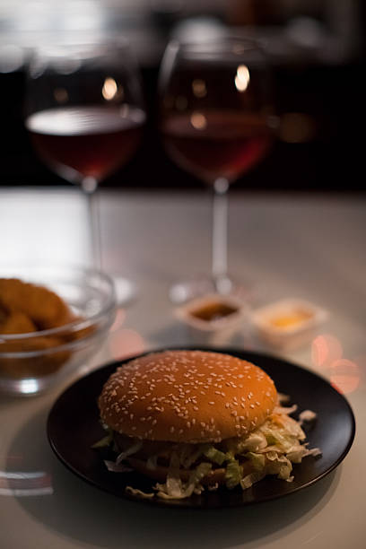 istock Two red wine glasses with lit candles behind, warm bokeh lights and romantic mood. g 2248956321