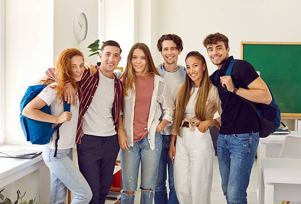 istock Group portrait og students in class classmates with bags are smiling, hugginh and looking at camera. 2248956452