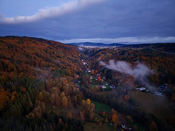 istock quiet village beneath misty hills, idyllic hamlet nestled under cloudcovered forested hill at dusk 2248963261