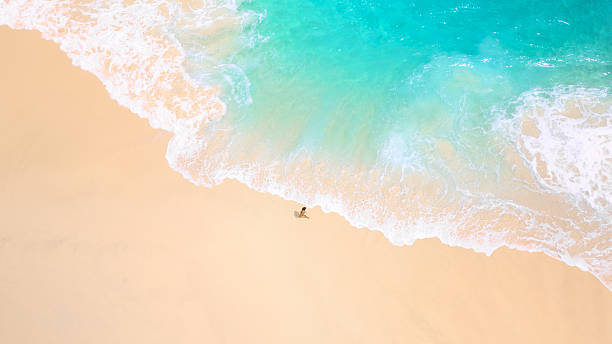 istock Serene Tropical Beach Waves Washing Over Lone Traveler On Sandy Shore 2248970040
