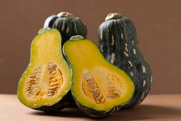 istock Half green butternut squash pumpkin on brown background 2248975208
