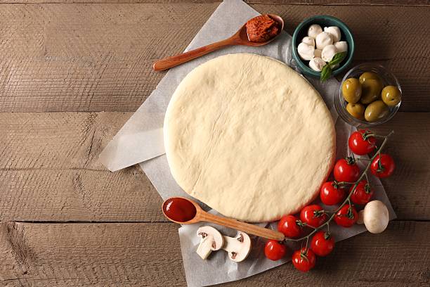 istock Pizza dough and products on wooden table, flat lay. Space for text 2248975620