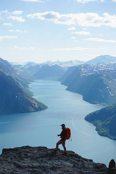 Young woman on viewpoint above lake and mountains, Besseggen hike