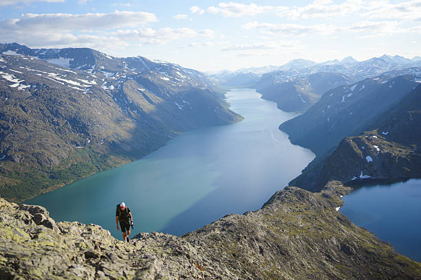 istock Young man on mountain ridge above lake 2248978015