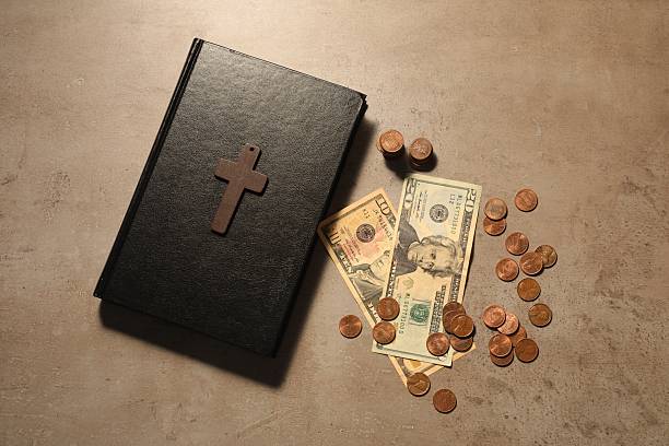 istock Donate and give concept. Coins, Bible, cross and dollar banknotes on grey table, flat lay 2248979029