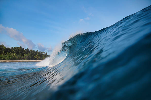 istock Energetic surf soaring over coral reef with dazzling sunlight reflections 2248979827