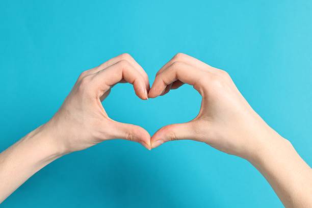 istock Woman showing heart gesture with hands on light blue background, closeup 2248982017