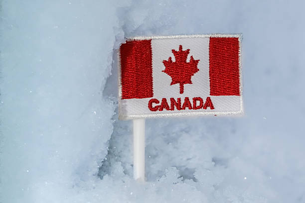 istock Canada flag patch in glacial snow, symbolizing northern winter travel, cold climate identity, and Arctic exploration themes. 2248991036