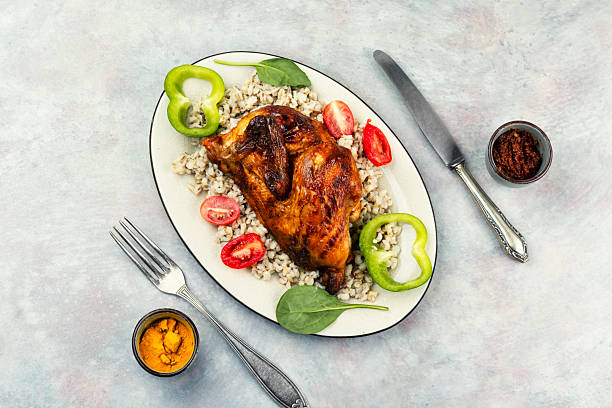 istock Half grilled chicken on the grill served with porridge. 2248992522