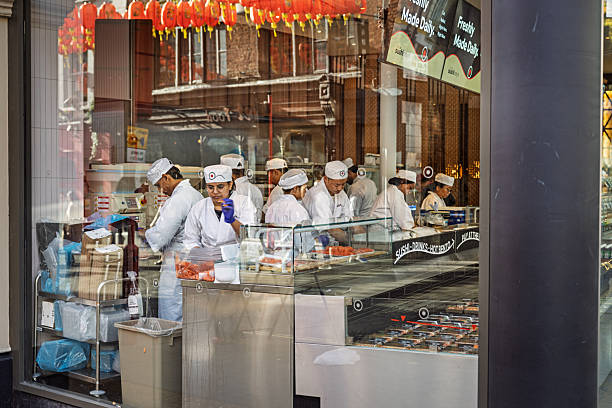 Chinatown, London, England, United Kingdom ,Europe - November 9th 2025: Restaurant staff working inside a spacious dining venue in London’s classic Chinatown. The central district has evolved in recent years from a rough past into a fashionable area with popular restaurants, while still maintaining strong elements of Chinese culture that shape its unique atmosphere.