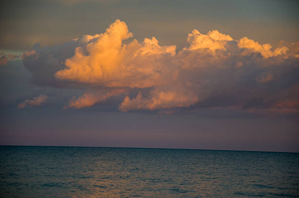 istock Golden sunset light illuminates dramatic cumulus clouds over the vast ocean horizon 2248994046