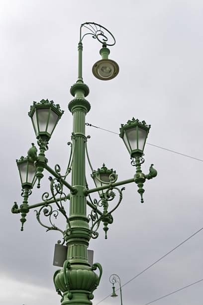 Budapest, Hungary - April 2025 The iconic Elizabeth Bridge, a historic bridge painted in green, stretches across the Danube River in Budapest, Hungary. Featuring intricate ironwork, tall gothic-style towers topped with statues, and vintage street lamps along its railings, the structure connects the Buda and Pest sides of the city. The river flows calmly below under an overcast sky, with a few distant pedestrians visible on the bridge. This image captures the architectural grandeur and engineering marvel of the 19th-century landmark on a cloudy daytime in autumn or spring. Ideal for commercial use in travel magazines, tourism campaigns, historical documentaries, urban planning articles, and European architecture features, highlighting Budapest's skyline and riverfront heritage.