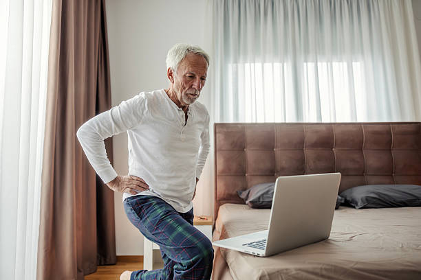 istock Senior man doing online workout with laptop at home 2248996021