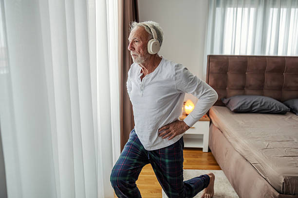 istock Senior man doing morning exercise at home wearing pajamas 2248996037
