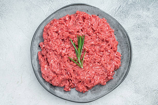 istock Uncooked raw minced pork and beef meat slab with herbs and pepper on rustic board highlighting raw texture for culinary and food preparation visuals. 2249002205