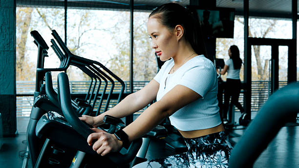 istock A woman is using a seated rowing machine to work her back muscles 2249002349
