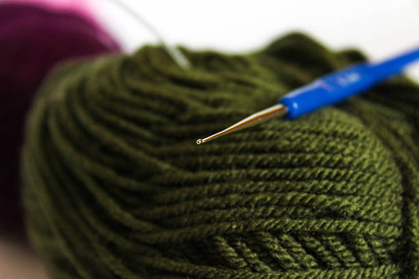 Close-up knitting on needles, warm yarn color, macro shot.