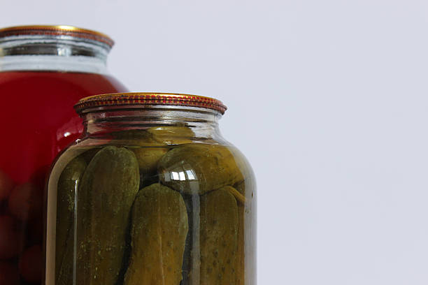 istock Foreground jar of pickled cucumbers with a second jar of red fruit compote softly out of focus behind it. 2249006895